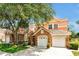 Charming townhome showcasing a stone facade, attached two-car garage, a neatly manicured lawn, and mature trees at 7521 Bay Port Rd # 12, Orlando, FL 32819