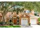 Charming two-story home featuring a stone facade, attached two-car garage, and a well-maintained lawn at 7521 Bay Port Rd # 12, Orlando, FL 32819