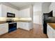 Open kitchen with granite countertops, modern appliances, white cabinets, and tile flooring at 7521 Bay Port Rd # 12, Orlando, FL 32819