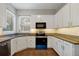Well-lit kitchen features granite countertops, white cabinets, and modern stainless steel appliances at 7521 Bay Port Rd # 12, Orlando, FL 32819