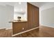 Open-concept view of a living room with wood floors and a bar counter leading to a kitchen with white cabinetry at 7521 Bay Port Rd # 12, Orlando, FL 32819