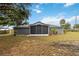Spacious backyard with a screened-in patio, providing a serene outdoor living space, surrounded by lush greenery at 8 Lake Jackson Dr, Mascotte, FL 34753