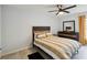 Bedroom with modern ceiling fan, wood look tile floors, and a bed with wood headboard at 8 Lake Jackson Dr, Mascotte, FL 34753