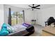 Bedroom with modern ceiling fan, wood look tile floors, and window with curtains at 8 Lake Jackson Dr, Mascotte, FL 34753