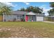 Lovely single-story home with a well-kept lawn, gray exterior, and an eye-catching red front door at 8 Lake Jackson Dr, Mascotte, FL 34753