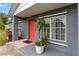 Close-up of a home's entrance, featuring a red door and a decorative potted plant at 8 Lake Jackson Dr, Mascotte, FL 34753