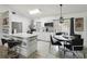 Bright kitchen with white cabinets, stainless steel appliances, island with bar seating, and an adjacent dining area at 8 Lake Jackson Dr, Mascotte, FL 34753