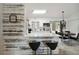Modern kitchen with white cabinets, stainless steel appliances, an island with a breakfast bar, and a dining table at 8 Lake Jackson Dr, Mascotte, FL 34753