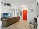 Bright living room with modern ceiling fan, a red front door, tile floors and lots of natural light at 8 Lake Jackson Dr, Mascotte, FL 34753