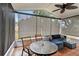 Relaxing sunroom featuring tile flooring, comfortable seating area and shades for privacy and views of the backyard at 8 Lake Jackson Dr, Mascotte, FL 34753
