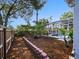 Landscaped backyard with flower bed, sitting area, and screened pool at 809 Palmetto Ter, Oviedo, FL 32765