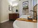 Bathroom with a tub, decor, wood-style tile accent wall, framed print, curtains, and vanity at 809 Palmetto Ter, Oviedo, FL 32765