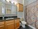 Standard bathroom with a patterned shower curtain, dark tile flooring, and a wood vanity at 809 Palmetto Ter, Oviedo, FL 32765