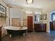 Primary bath with a clawfoot tub, tile flooring, wood-look accent wall, and natural light at 809 Palmetto Ter, Oviedo, FL 32765