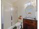 Bathroom featuring a shower, wood vanity with a black counter, round mirror, and towels at 809 Palmetto Ter, Oviedo, FL 32765
