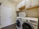 Laundry room features front-load machines, white cabinets, and neutral paint at 809 Palmetto Ter, Oviedo, FL 32765