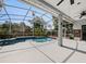Screened-in pool with ceiling fans, lush landscaping, and inviting blue water at 809 Palmetto Ter, Oviedo, FL 32765