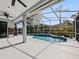 Screened-in pool with ceiling fans, lush landscaping, and inviting blue water at 809 Palmetto Ter, Oviedo, FL 32765