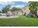 Spacious backyard with green grass, a play set, and lounge chairs by the pool at 8652 Savory Dr, Orlando, FL 32825