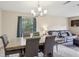 Bright dining area featuring a wooden table, upholstered chairs, and a modern chandelier at 8652 Savory Dr, Orlando, FL 32825