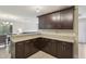 Well-lit kitchen featuring granite countertops and dark wood cabinetry, connecting seamlessly to an adjacent living space at 8652 Savory Dr, Orlando, FL 32825