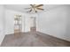 Neutral bedroom showcasing carpet, ceiling fan, and doorway to bathroom at 8801 Latrec Ave # 8107, Orlando, FL 32819