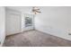 Bright bedroom features neutral carpet, ceiling fan, and a window for natural light at 8801 Latrec Ave # 8107, Orlando, FL 32819