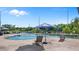 Resort-style pool with lake view, surrounded by lounge chairs and umbrellas for relaxation and enjoyment at 8801 Latrec Ave # 8107, Orlando, FL 32819