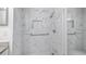 Shower features marble-style tile, built-in shelving, and grab bars at 8801 Latrec Ave # 8107, Orlando, FL 32819