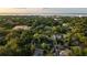 An aerial view shows a neighborhood with lush greenery and a glimpse of the water in the distance at 911 S Oak Ave, Sanford, FL 32771