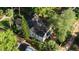 An aerial view showcasing a home with a dark roof surrounded by lush green trees and a fenced backyard at 911 S Oak Ave, Sanford, FL 32771