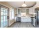 Bright kitchen featuring white cabinets, stainless steel appliances, and a door leading to the outside at 911 S Oak Ave, Sanford, FL 32771