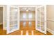 Living room with a large set of french doors and gleaming hardwood floors at 911 S Oak Ave, Sanford, FL 32771