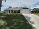 Single-story home with a two-car garage, gray and brick exterior, and a well-manicured front lawn at 943 Millenbeck Ave, Deltona, FL 32725