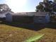 Exterior view of the house showcasing the large, screened-in patio and spacious lawn at 943 Millenbeck Ave, Deltona, FL 32725