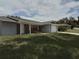 Single-story home featuring a combination of red brick and gray siding, a front-facing garage, and lawn at 943 Millenbeck Ave, Deltona, FL 32725