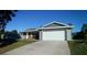 Exterior view of a single-story house with an attached garage and a concrete driveway at 943 Millenbeck Ave, Deltona, FL 32725