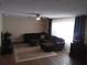 Comfortable living room featuring wood-look floors, a plush couch, and contemporary decor at 943 Millenbeck Ave, Deltona, FL 32725