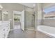 A well-lit bathroom with a glass shower, soaking tub, and double sinks at 10417 Oakview Pointe Ter, Gotha, FL 34734