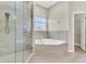 Bathroom showcasing a glass shower, soaking tub, and tile accents at 10417 Oakview Pointe Ter, Gotha, FL 34734
