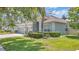 Landscaped front yard showcases this single-story home with an attached three-car garage, enhancing curb appeal at 10417 Oakview Pointe Ter, Gotha, FL 34734