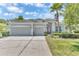 Beautiful single-story home with a well-manicured lawn, three-car garage, and a charming red front door at 10417 Oakview Pointe Ter, Gotha, FL 34734