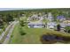 Wide aerial view of a community featuring manicured lawns, ponds, and colorful townhouses at 105 Wood Duck Cir # D, Daytona Beach, FL 32119