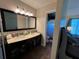 Bright bathroom featuring double sinks, a black vanity, and a large mirror at 105 Wood Duck Cir # D, Daytona Beach, FL 32119
