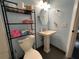Powder blue bathroom features a pedestal sink, toilet and shelving unit for storage at 105 Wood Duck Cir # D, Daytona Beach, FL 32119