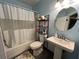 Blue-walled bathroom features a shower-tub combo, toilet and a pedestal sink at 105 Wood Duck Cir # D, Daytona Beach, FL 32119