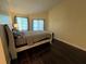 Relaxing bedroom boasts dark wood floors and natural light from the sliding glass door at 105 Wood Duck Cir # D, Daytona Beach, FL 32119
