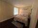 Bedroom with hardwood floors and a decorative painting above the white headboard at 105 Wood Duck Cir # D, Daytona Beach, FL 32119