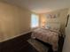 Bedroom with hardwood floors and a decorative painting above the white headboard at 105 Wood Duck Cir # D, Daytona Beach, FL 32119