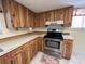 Spacious kitchen featuring natural wood cabinetry and modern stainless steel appliances at 105 Wood Duck Cir # D, Daytona Beach, FL 32119